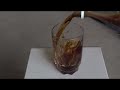 slowmo pouring cola coke rootbeer into glass and it spilling outside of glass