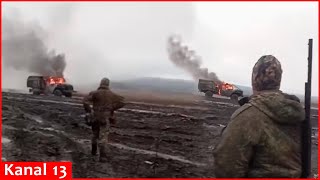 Russian servicemen show a burning truck struck by kamikaze drones