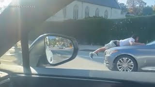 Bizarre video shows man clinging to hood of moving car in Hollywood