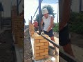 Каменщики кладут кирпичные столбы для забора. fence construction