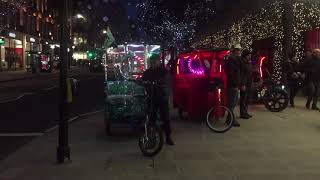 A pedicab (bicycle taxi or rickshaw) moving down Oxford Street, London, UK