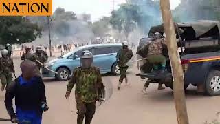 Anti-riot police take cover after protesters overpowered them in Wote, Makueni