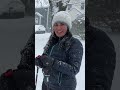 Family skis through snowy streets