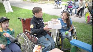 children with physical development disorders on wheelchairs eating cookies