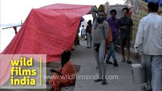 A young sadhu with his face and body smeared with ash at Varanasi