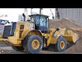 cat 962m wheel loader filling trucks with sand