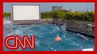shows what happened when a man was swimming during the massive earthquake