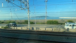 瀬戸内海の朝日を浴びる明石海峡大橋と淡路島。海岸線を走るJR神戸線快速　須磨→明石