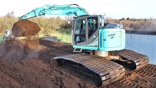 Kobelco with Ultra Wide Tracks loading trucks