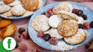 Poffertjes made from yeast dough with powdered sugar and berries