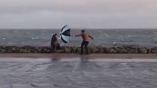 Guy Skateboards On The Beach With Umbrella - 1106270