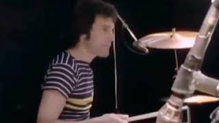 Freddie Mercury playing drums and Roger Taylor playing guitar
