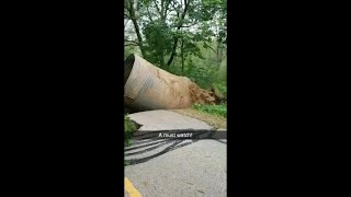 Flood waters force culverts up through road and into river