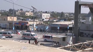 Ambulances wait at Gaza crossing into Egypt, aid trucks enter the besieged Strip
