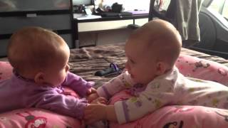 Twin babies talk and hold hands for the first time