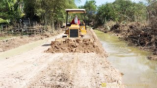 Professional Driver MITSUBISHI BD2G Bulldozer Pushing Dirt To Constructs New Road In a Small Village