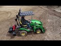 tiny tractor tackles stumps with front hoe bucket