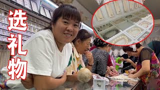 Dalong and his daughter-in-law go to a jewelry store on the street, choosing gifts for their mothers