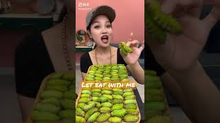 Beautiful Chinese girl eating green worms