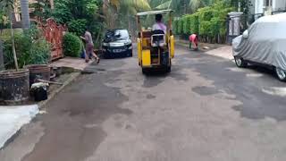 Proses pengaspalan jalan komplek dengan alat manual