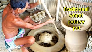 Making a traditional wheel pottery pot. Ancient style wooden wheel clay pot making process.