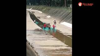 Group of men fish illegally in canal with huge nets despite warning sign