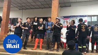 Thai volunteers dance as they celebrate successful rescue mission