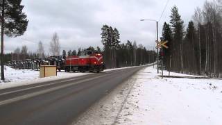 Freight train full of tractors passed level crossing near VALTRA factory in Suolahti, Finland