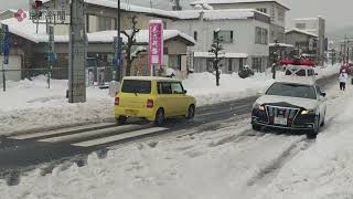 乗用車のスタックが発生した国道178号線で、鍬やツルハシを使い除雪作業する警察官ら（2024年1月25日　京都府宮津市）　Police officers working to remove snow