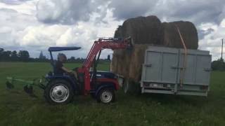 Loading hay bales on to truck with foton tractor