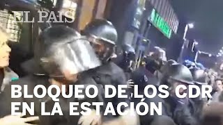 Los Mossos ayudan a una pasajera a entrar en la estación de Sants ante el bloqueo de los CDR