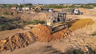 What a huge powerful Dozer Komatsu D65 leveling path with long trucks carrying dirt