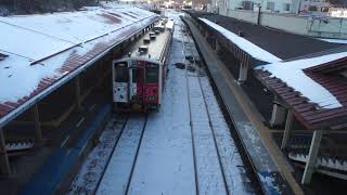 雪に覆われた網走駅の跨線橋から見降した赤と白の釧網本線「地球探索鉄道花咲線ラッピングトレイン」キハ54形