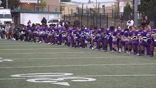 Entire high school football team kneels during national anthem