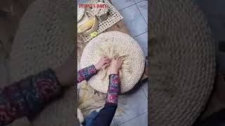 Chinese craftswoman magically weaves corn husks into a round cushion, also called Putuan in China.