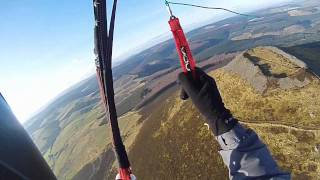 Paragliding over the top of the Hill Fort on the Tap O Noth, Rhynie, Aberdeenshire, Scotland.