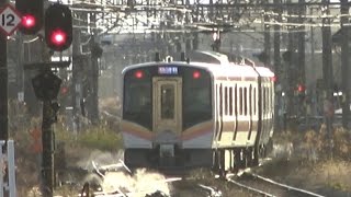 新発田駅を出発する羽越線から白新線直通のE129系とポイントの凍結を防止するスプリンクラー群の放水