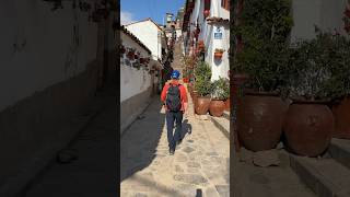 Beautiful white buildings with hanging pots on the steep stairs of Calle Siete Borreguitos in Cusco