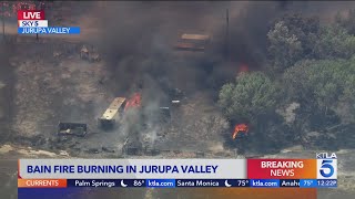 Crews battling brush fire burning structures in Jurupa Valley