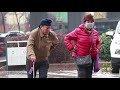 an unwell old man sits alone in the street on a rainy day what will passers by do