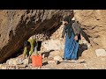 building a structure in the mountains by a poor mother and her child with stones