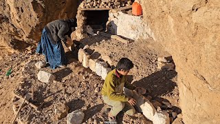 Building a structure in the mountains by a poor mother and her child with stones