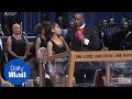 Bishop Charles Ellis holds Ariana Grande tight in awkward exchange