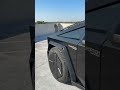 tesla cybertruck with a gloss black metallic wrap