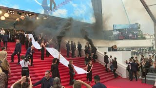 Cannes: Feminist collective deploys banner, smoke bombs on red carpet | AFP