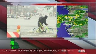 Ouch! Bicyclist trekking through flooded street takes a tumble!