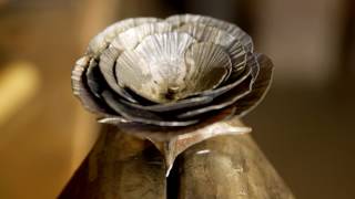 Blacksmith forging a rose from steel