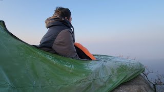 Camping without a tent on top of a rocky mountain