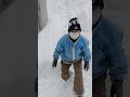 車庫の雪下ろしでできた山から滑り下りる