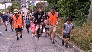 Plucky youngster bounces his pogo stick all the way up Dunedin's steepest street